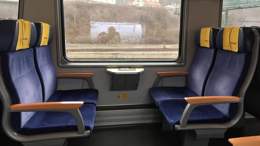 RegioJet Economy class on the Vienna to Prague train — blue seats with yellow RegioJet headrests